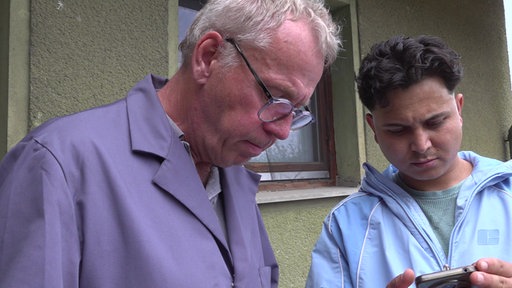 Auf dem Foto sieht man den jungen Afghanen Khair Mohammad Dilawari mit einem Handy.