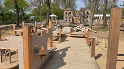 Ein Spielplatz mit viel Sand und Holzbauten