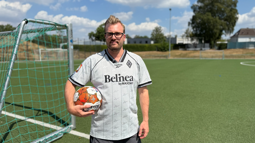 Mirco Schwoll hält einen Ball in seinem Arm und schaut in die Kamera.