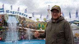 Ein Schausteller auf der Kirmes vor seinem Fahrgeschäft.