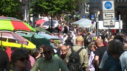 Menschen auf der Luisenstraße bei sonnigem Wetter, Links im Bild mit großen Sonnenschrime