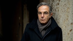 Navid Kermani vor einer Wand