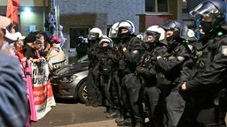 Teilnehmer werden bei einem "Anti-Kriegs-Marsch" der Initiative "Rheinmetall Entwaffnen" durch die Polizei (r) eingekesselt