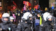 Teilnehmer (hinten) werden bei einem "Anti-Kriegs-Marsch" der Initiative "Rheinmetall entwaffnen" durch die Polizei eingekesselt
