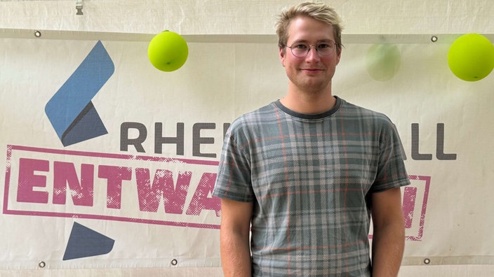  Jona Fischer der Organisator steht vor einem Plakat mit der Aufschrift  "Rheinmetall entwaffnen"