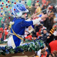 Ein Karnevalist wirft Süßigkeiten ins Publikum, Rosenmontagszug Köln