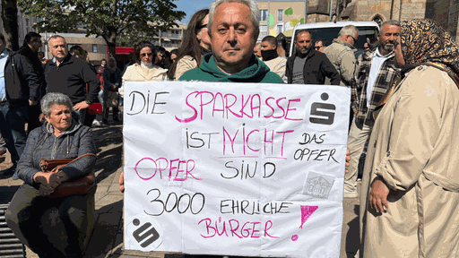 Teilnehmer der Demo hält Plakat in der Hand