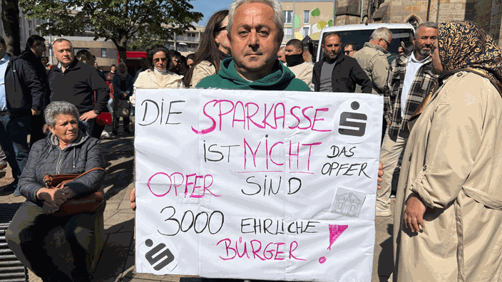 Teilnehmer der Demo hält Plakat in der Hand