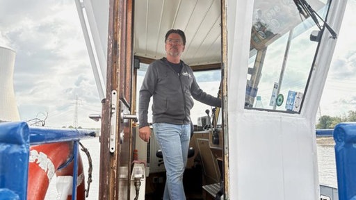 Dirk Nowakowski steht am Steuer seiner Fähre und schaut aus seinem Fenster