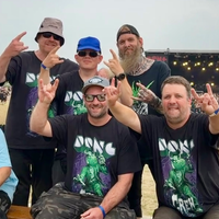 Die siebenköpfige Gruppe der GSE mit der Bühne des Dong Open Air im Hintergrund