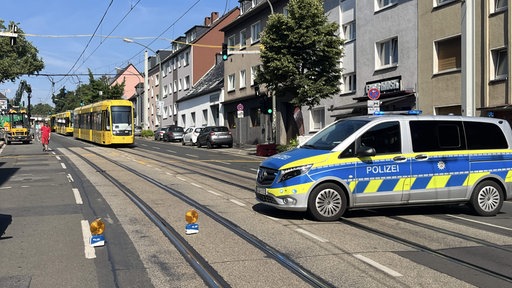 Ein Polizeiwagen sperrt die Altendorfer Straße in Essen. Dahinter warten drei Straßenbahnen.