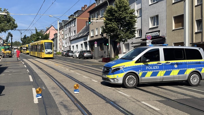 Ein Polizeiwagen sperrt die Altendorfer Straße in Essen. Dahinter warten drei Straßenbahnen.