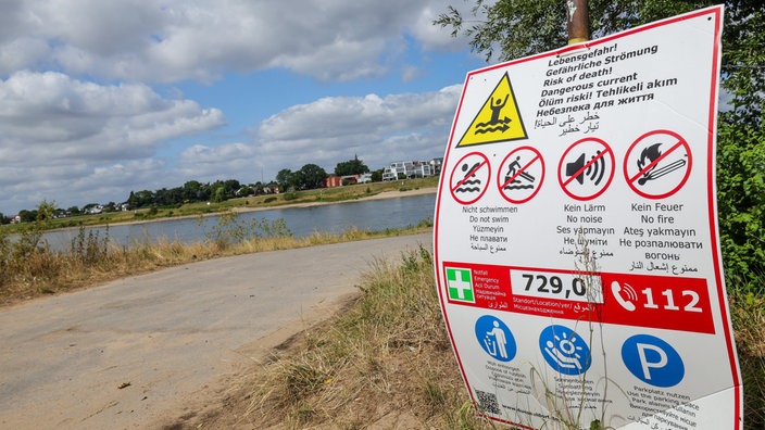 Ein Schild an Rheinkilometer 729 in Himmelgeist warnt vor Lebensgefahr im Rhein durch gefährliche Strömung.