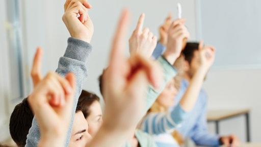 Viele Schüler melden sich im Unterricht