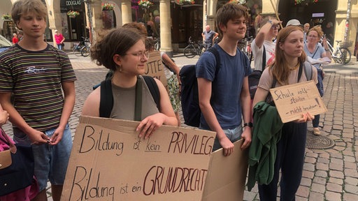Schüler halten Plakate mit der Aufschrift "Bildung ist kein Privileg, Bildung ist ein Grundrecht"