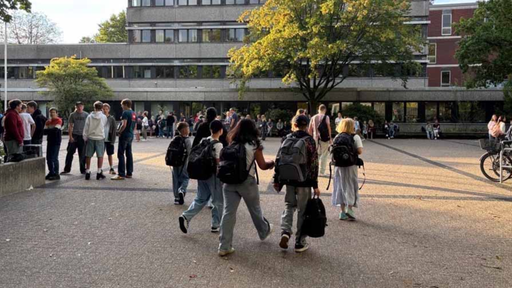 Auf einem Platz vor einem Gebäude sind einige Kinder
