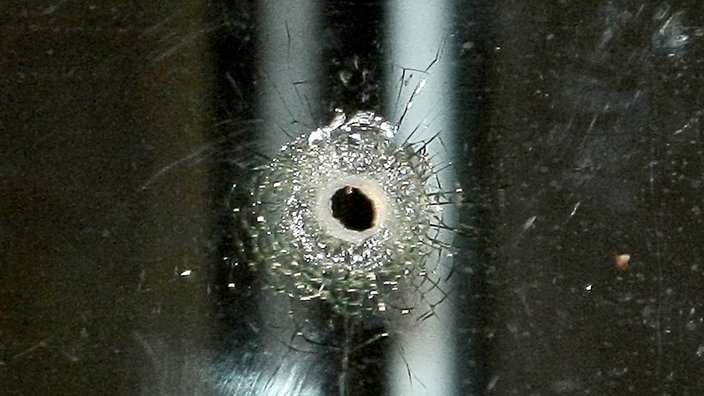 Symbolbild eines Schusslochs in einem Fenster