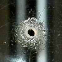 Symbolbild eines Schusslochs in einem Fenster