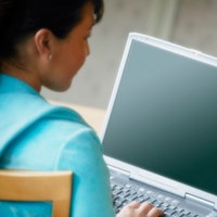 Eine junge Frau hat einen Laptop auf ihrem Schoß