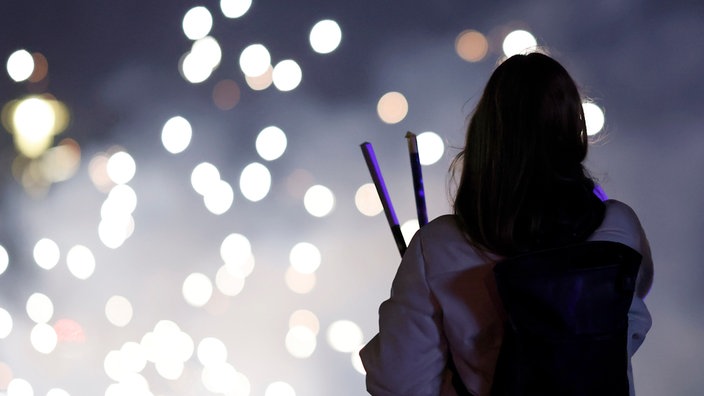 Eine Person schaut sich Silvester-Raketen an