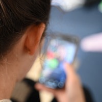 Eine junge Frau schaut auf ihr Smartphone