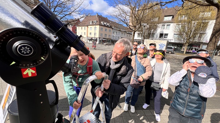 Ein Teleskop in der Schwelmer Innenstadt wird zur Beobachtung der Sonnenfinsternis am 29.03.2025 genutzt