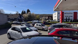 Vor einer Tankstelle in Bielefel stehen Autos am 8. April 2026 in einer Schlanke für Benzin an