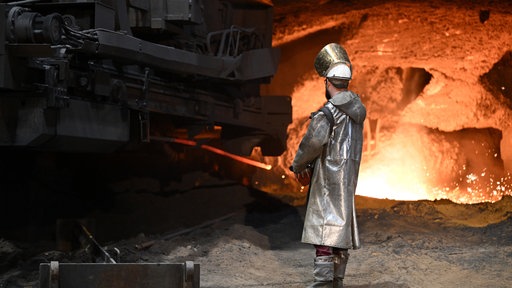 Ein Stahlarbeiter steht an einem Hochofen von Thyssenkrupp Steel