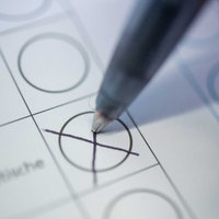 Eine Person macht ein Kreuz auf einem Wahlzettel