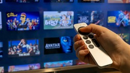 Mit einer Fernbedienung werden Filme und Serien in einem Streamingdienst ausgewählt