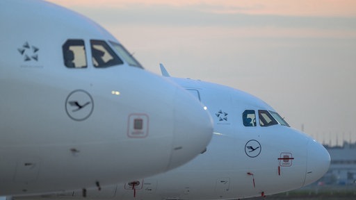 Zwei Flugzeuge stehen auf der Rollbahn eines Flughafens