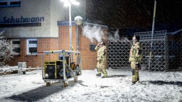Einsatzkräfte der Berliner Feuerwehr vor einem Generator-Lichtmast