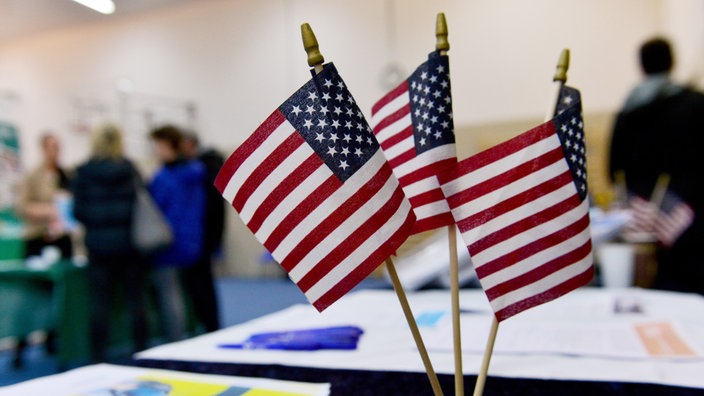 Drei kleine Amerikanische Flaggen stehen auf einem Tisch bei einer Schüleraustausch-Messe in Berlin