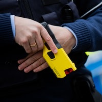 Ein Polizist hält einen Taser