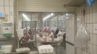 Mehrere Arbeiter sitzen eng beieinander in der Kantine des Fleischherstellers Tönnies.