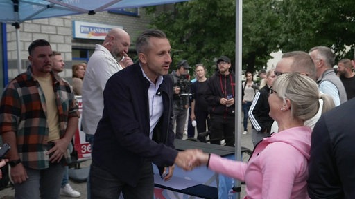 AfD-Spitzenkandidat Ulrich Siegmund schüttelt die Hand einer Frau im Wahlkampf