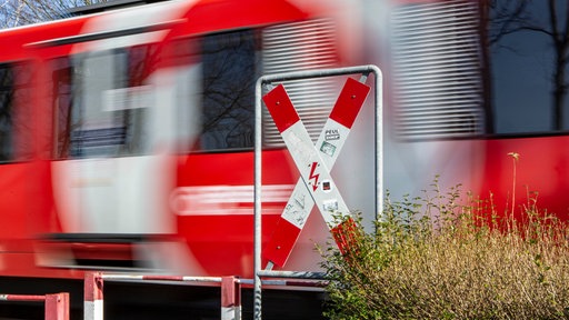 Zug fährt durch an einem unbeschrankten Bahnübergang in Königswinter mit Andreaskreuz