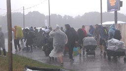 Festival-Besucher werden bei der Anreise vom Regen durchnässt