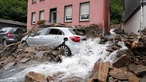 Ein Auto unter den durch starkes Unwetter verursachten Trümmern
