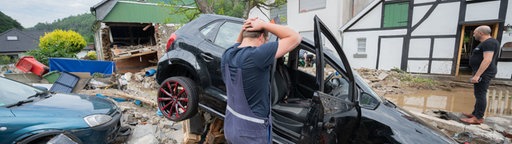 Hagen: Ein Anwohner steht vor seinem zerstörten Auto im Ortsteil Hohenlimburg