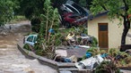 Das Wasser fließt eine Straße im Ort entlang, zerdrückte Autos liegen auf einer Zufahrt. Der Vichtbach war hier über die Ufer getreten.