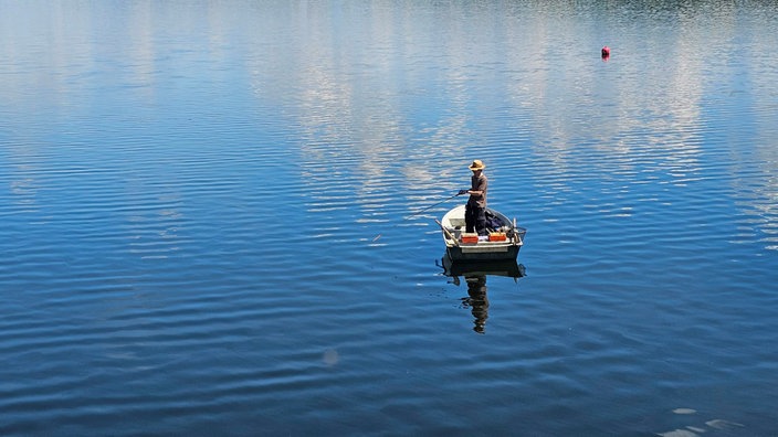 Ein Angler auf einem Boot auf der Möhnetalsperre