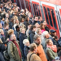 Fahrgäste steigen auf einem überfüllten Bahnsteig in eine Bahn ein
