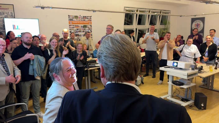 Raum voller applaudierender Menschen. Im Vordergrund SPD-Oberbürgermeisterkandidat Thorsten Berg.