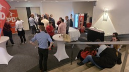 Ein paar SPD-Parteimitglieder stehen vor einer verschlossenen Tür.