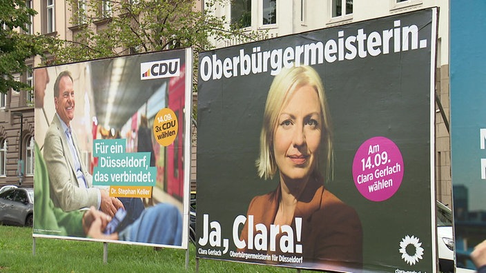 Wahlplakate von Stephan Keller und Clara Gerlach an einer Straße in Düsseldorf