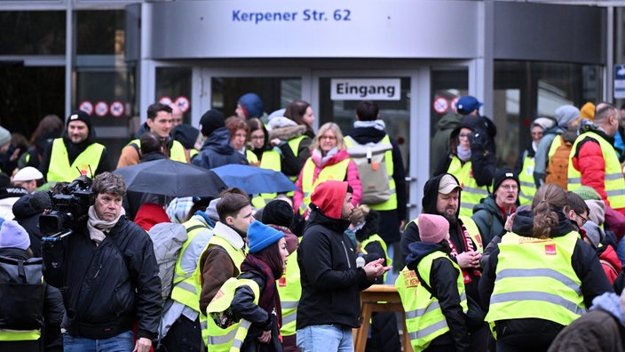Beschäftigte der Uniklinik stehen bei einen Warnstreik vor dem Haupteingang. 