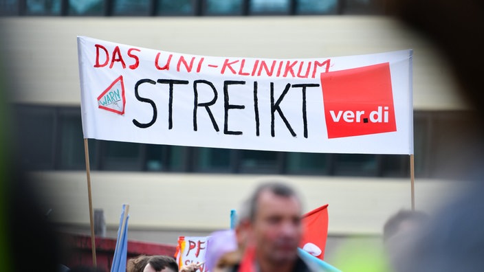 Mernschen halten Plakate zur Demonstration in die Höhe