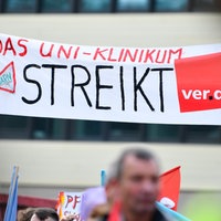 Mernschen halten Plakate zur Demonstration in die Höhe