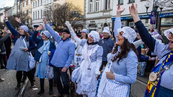 Jeckinnen und Jecken am Rande des Weiberfastnachtszugs in Bonn-Beuel